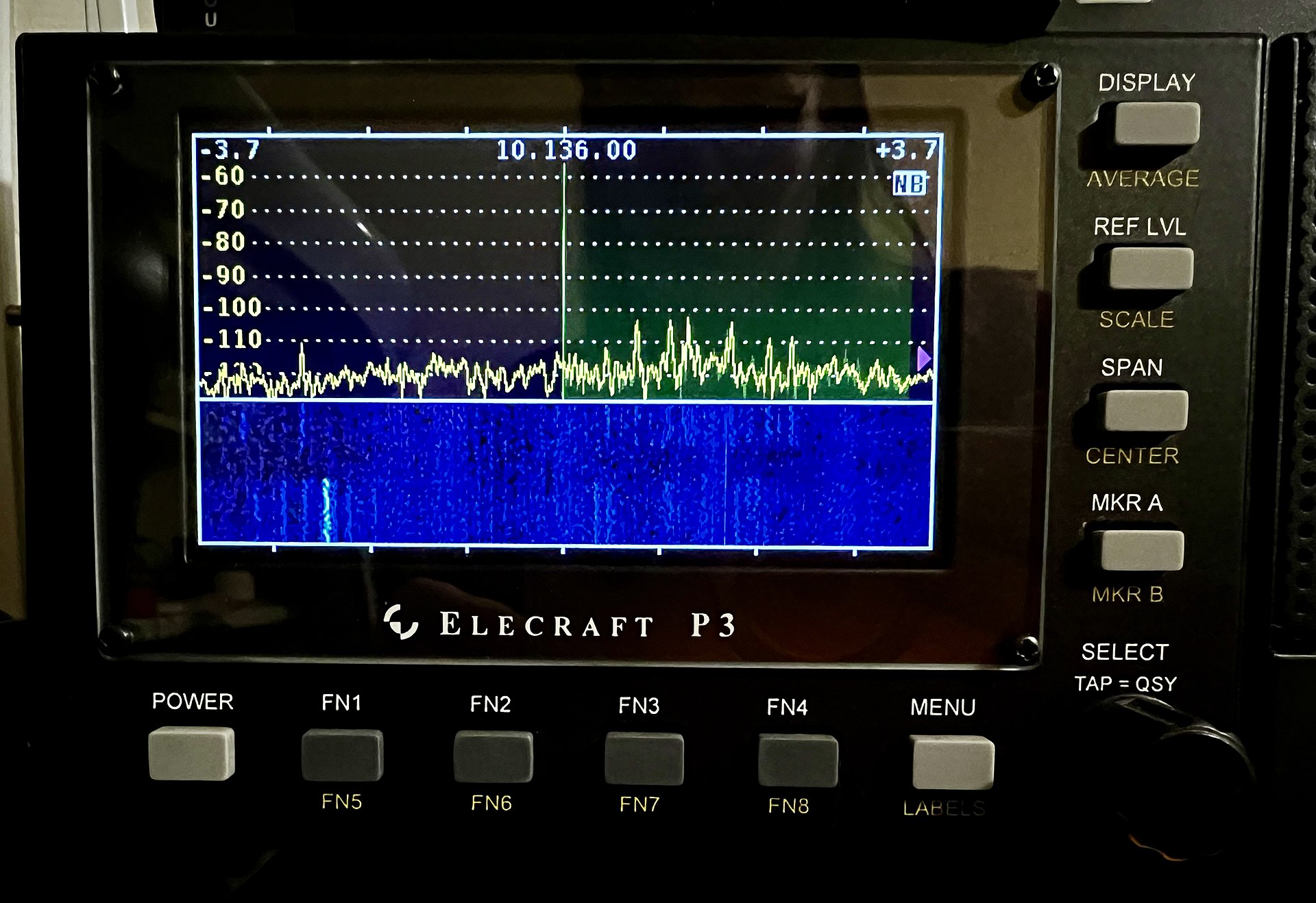 Figure 4 — The same view built into a station: an Elecraft P3 panadapter beside a transceiver, a slice of the band drawn as a spectrum trace above and a scrolling waterfall below. Tuning is sliding a window a…
