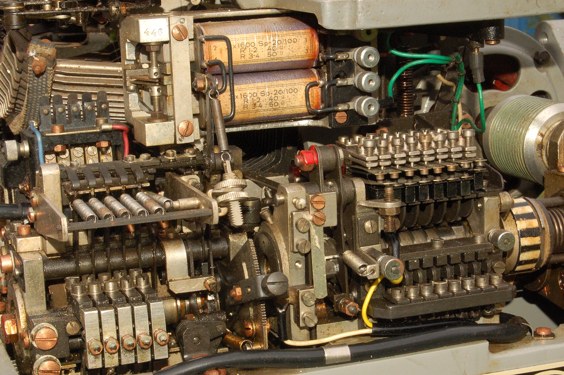 Figure 3 — Cams, pivoted levers, springs and a relay — a teleprinter's receiving mechanism with the covers off. There is nothing electronic anywhere in it: every decision about every element is made by a movi…